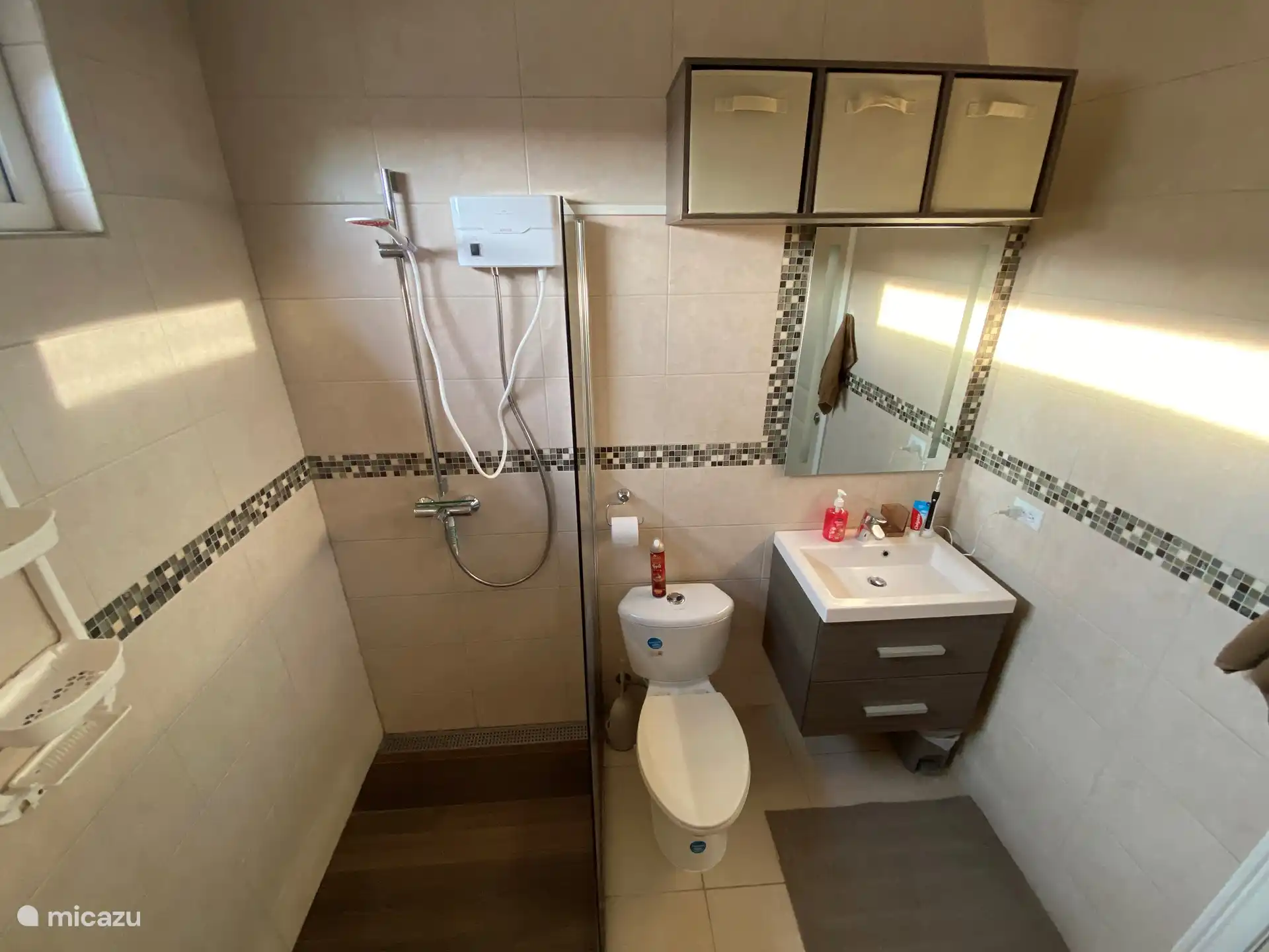 Grande salle de bain avec douche à l’italienne (eau chaude) et lavabo au milieu de la maison.