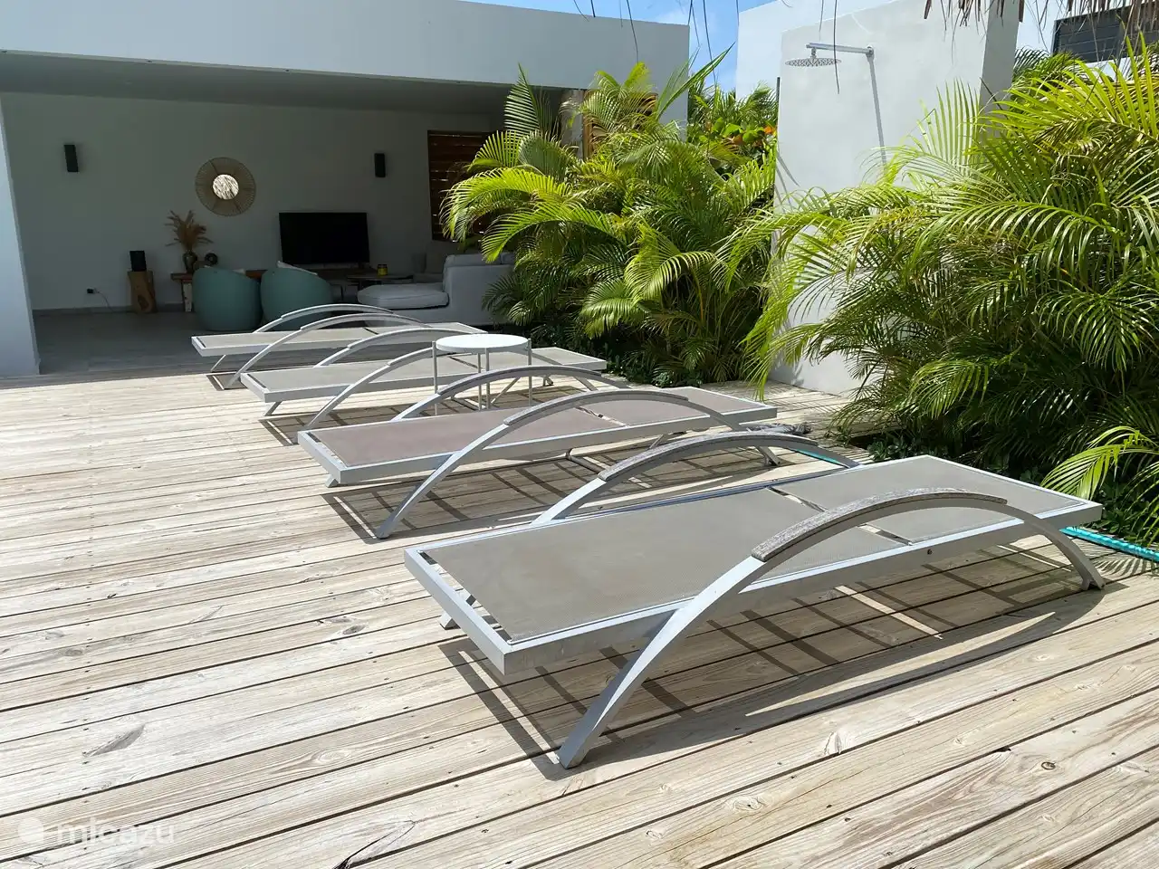 Terrasse avec 4 transats et une douche extérieure