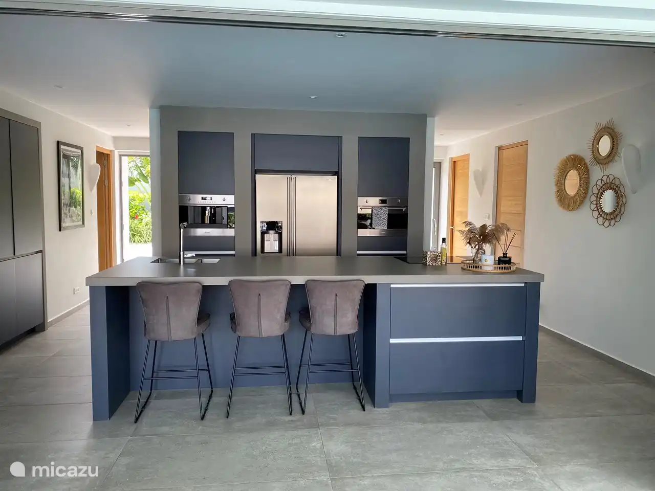 La cuisine ouverte avec 3 chaises de bar