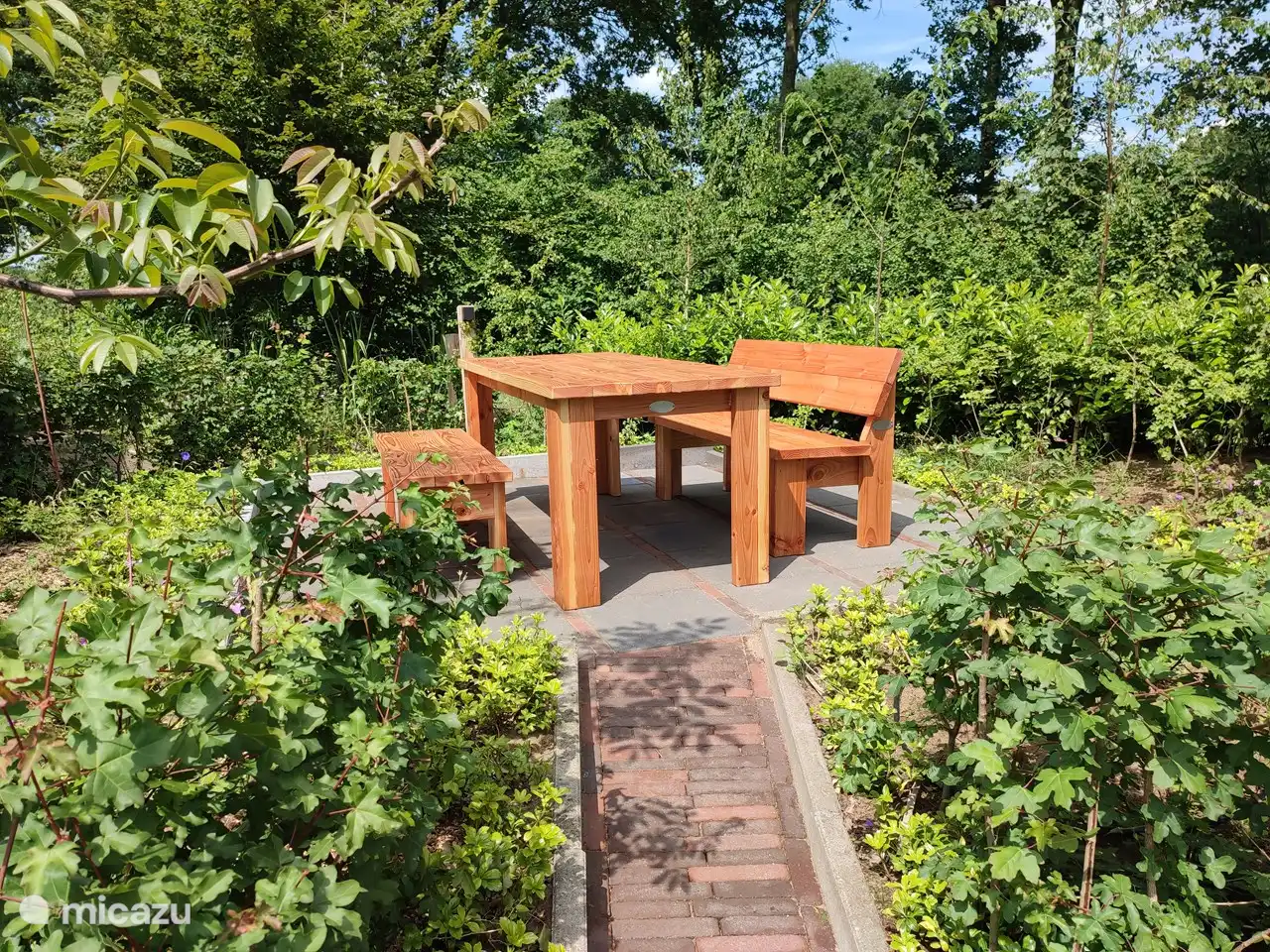 Schöner Sitzplatz mit stabilem Tisch und Bänken. Oh, auch genug Steckdosen und Lichter im Garten
