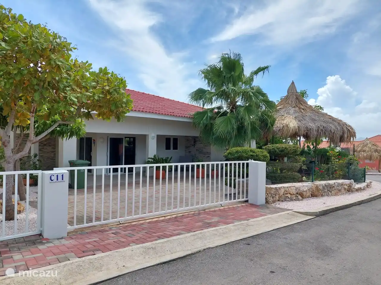 À l'avant de la maison, il y a un grand parking pour la voiture.
