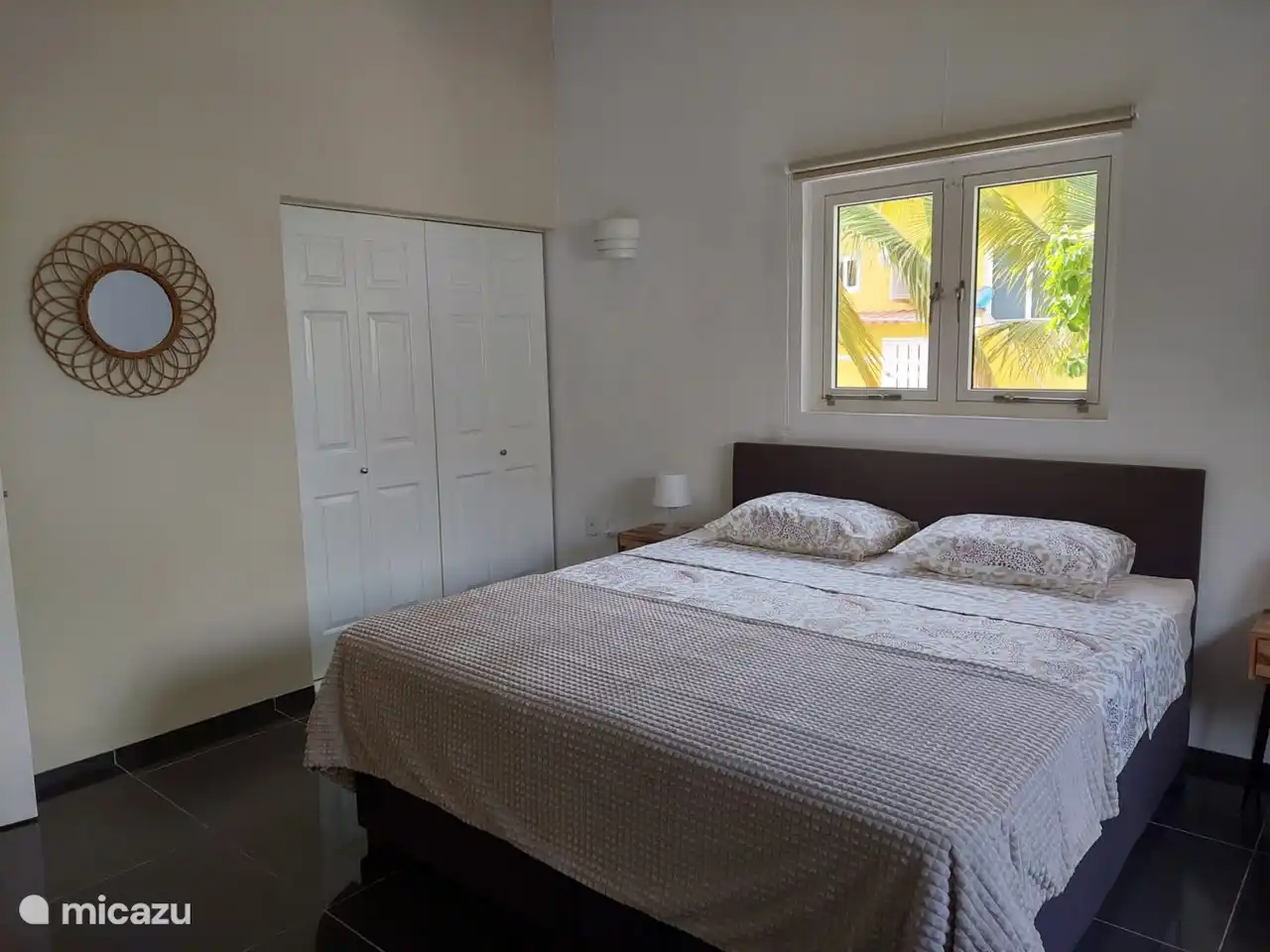 La chambre principale avec un sommier tapissier de 180 x 200 avec une grande armoire intégrée et la climatisation adjacente à la salle de bain.