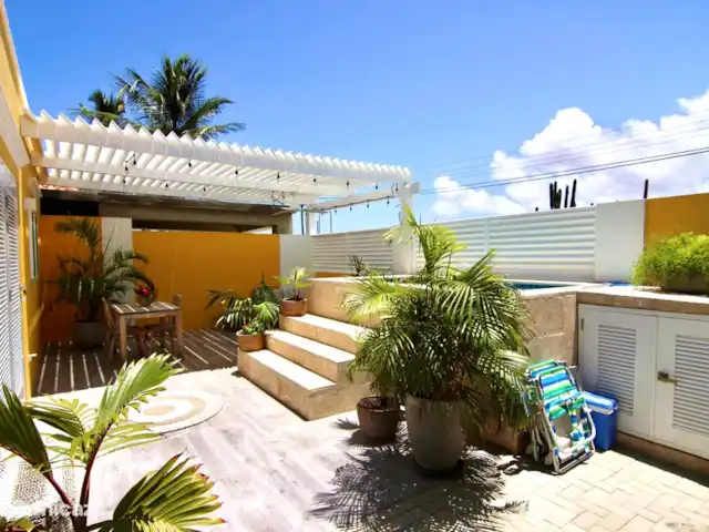 Location de Vacances Aruba, Nord, Nord, maison de vacances - Casita de luxe avec piscine privée Terrasse spacieuse, décorée de plantes et de palmiers. Utilisation gratuite de deux chaises longues et d'une glacière.