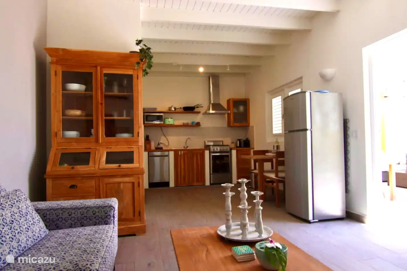 Amplio y acogedor salón con cocina abierta. La cocina tiene mesa de comedor y heladera con freezer.