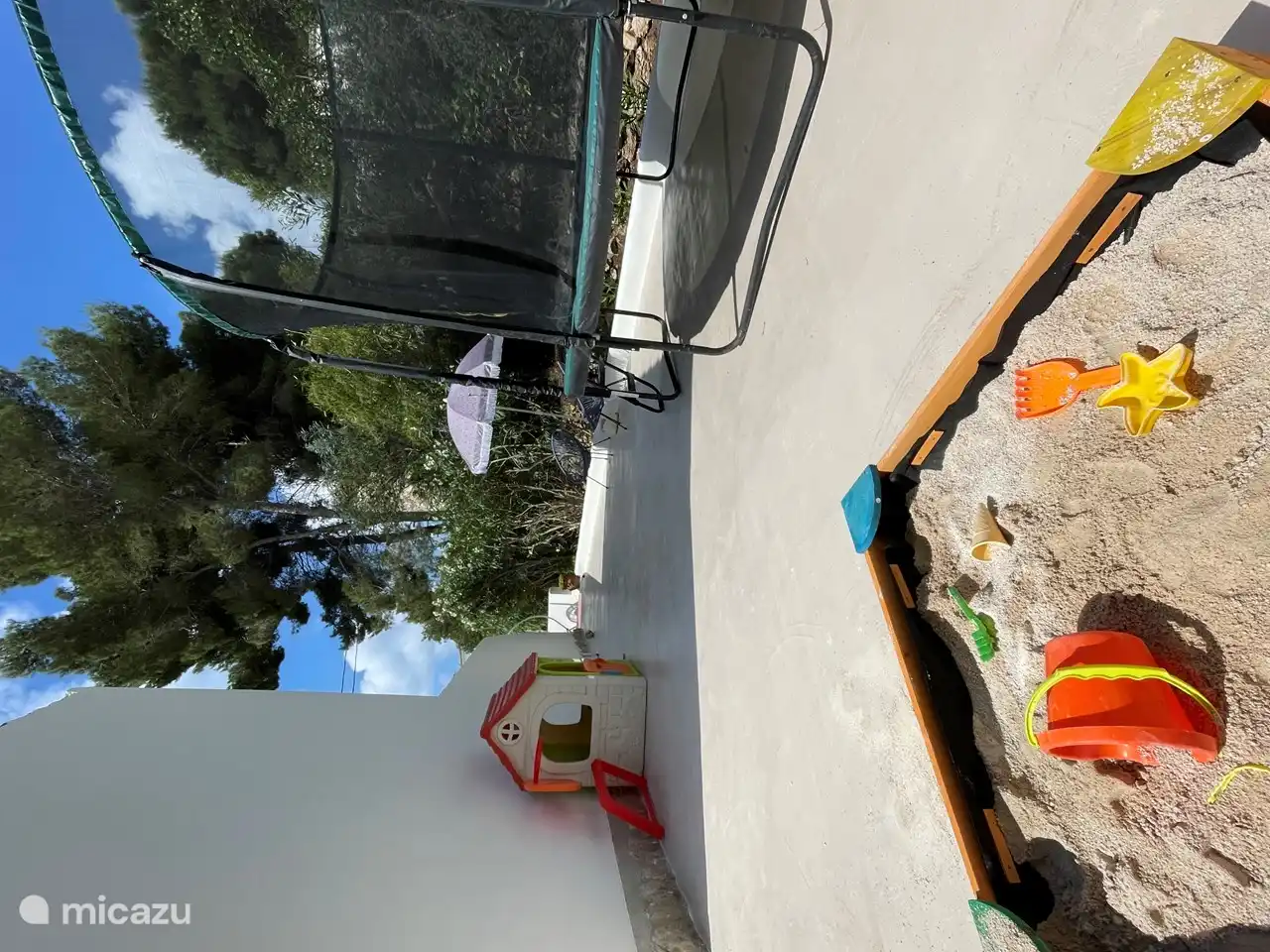 Terrasse de jeux pour enfants avec trampoline, maisonnette, bac à sable et tapis