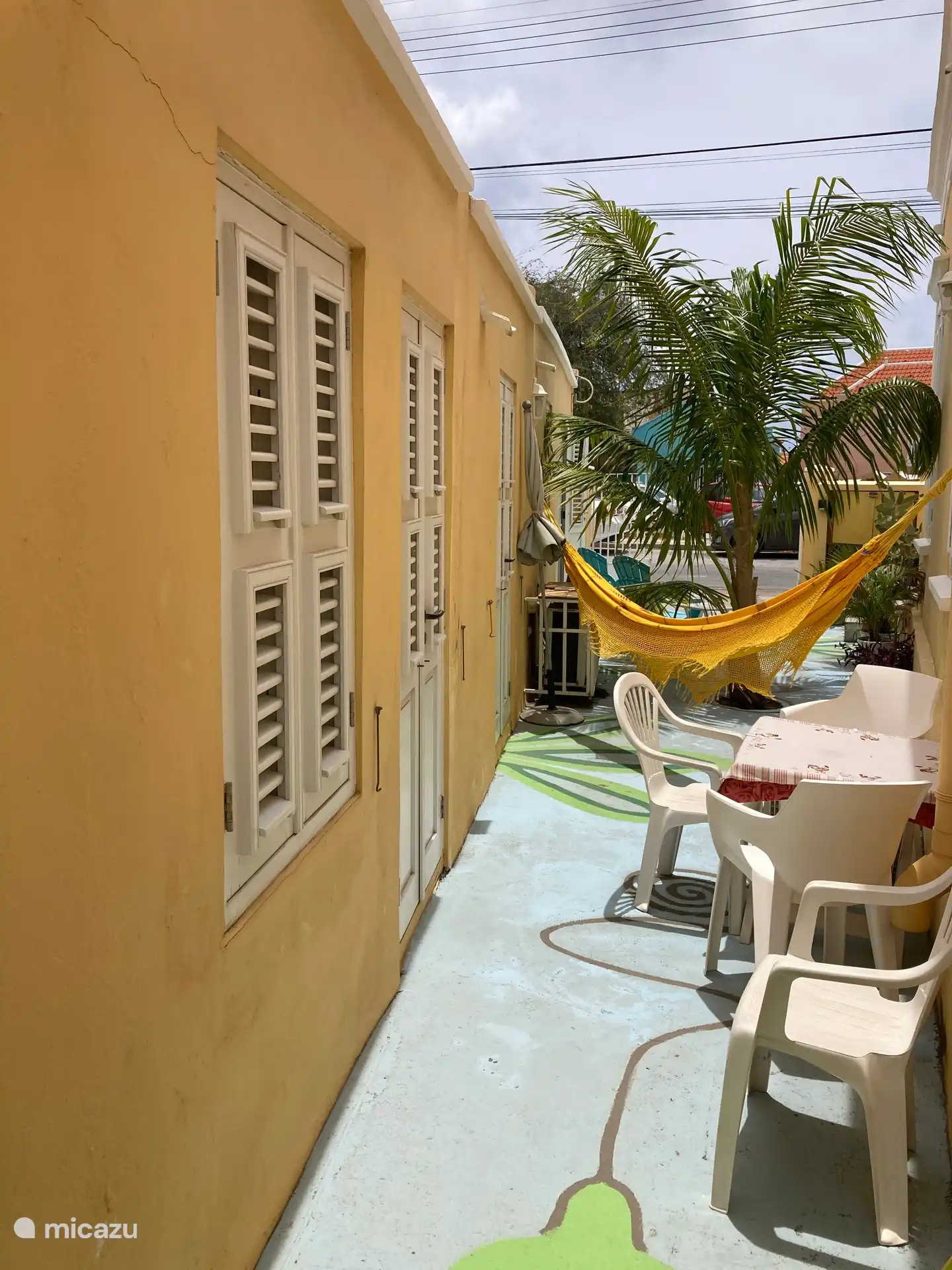 Hangmat en zitje en doorkijk naar straat. Louvredeuren naar slaapkamer en badkamer