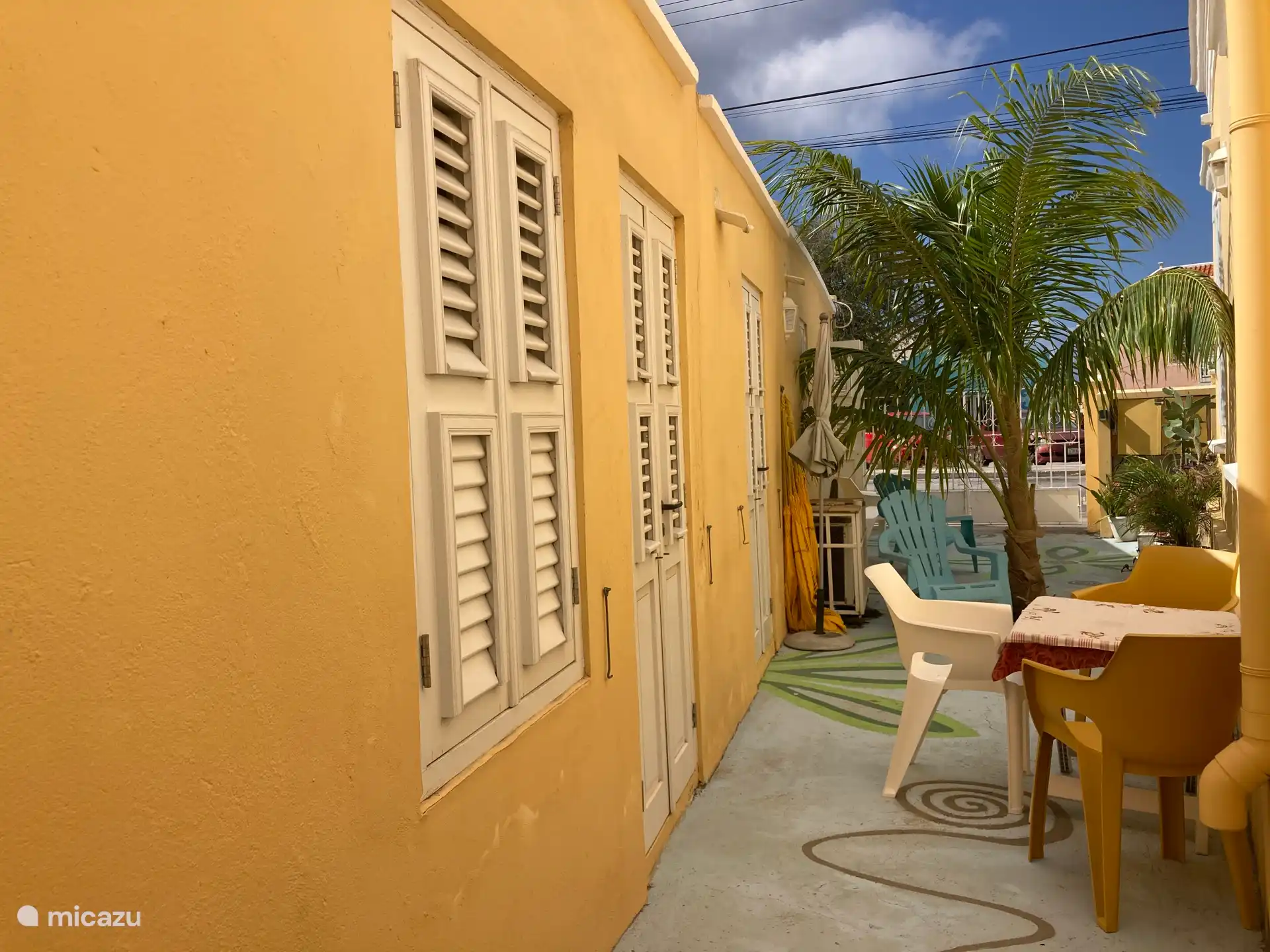 Terrasse avec palmiers, plantes, divers espaces de repos et/ou un parking.