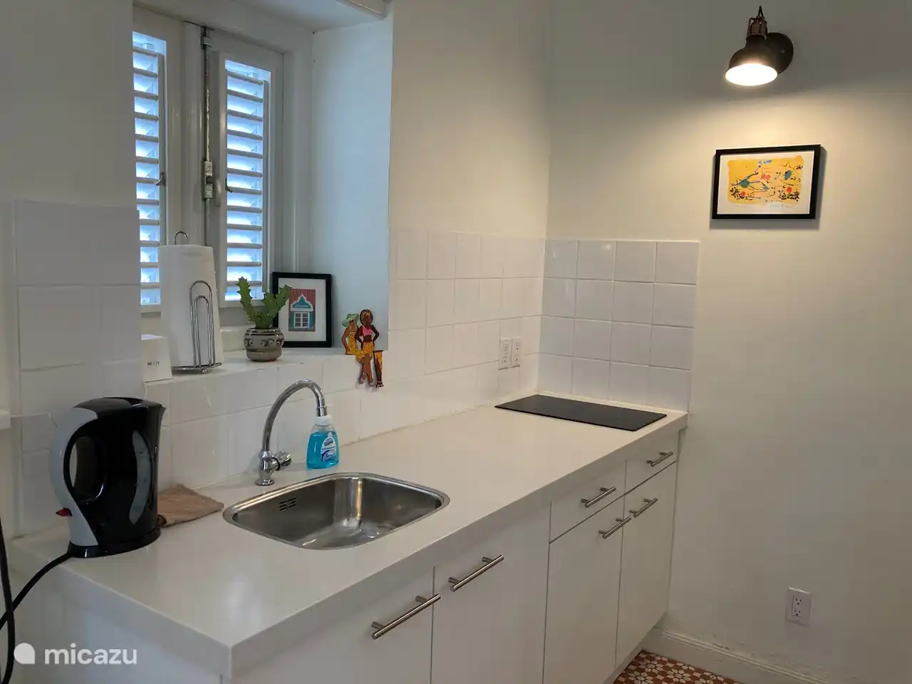 Küche mit 2-Platten-Cerankochfeld und Kühl-/Gefrierschrank sowie Pfannen und Besteck.