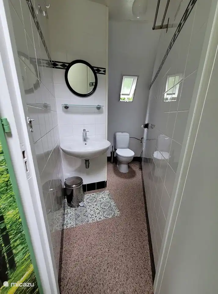 Ordentliches Badezimmer mit Waschbecken, Toilette und Dusche.