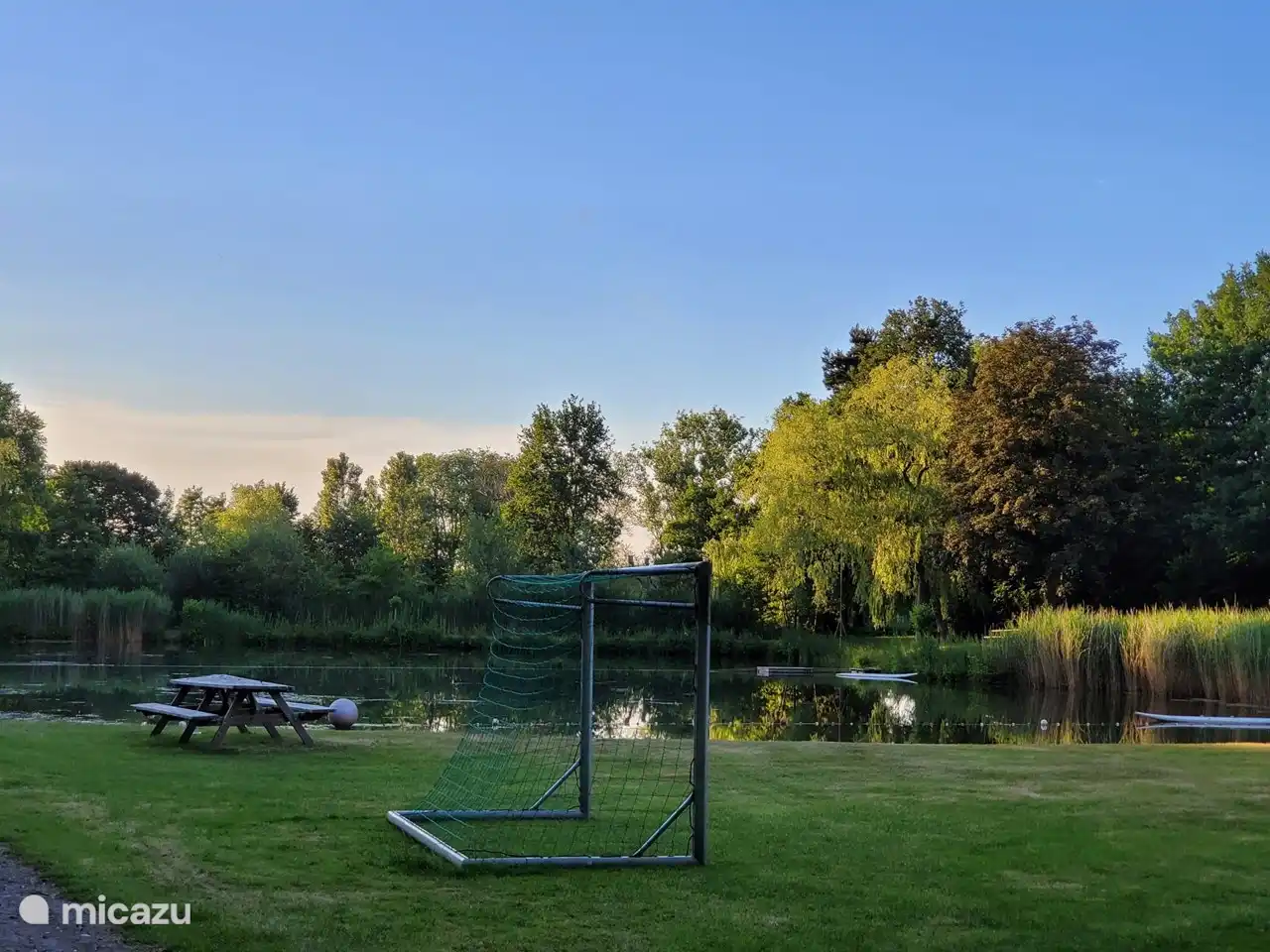 Es gibt einen schönen Schwimmteich mit Strand, Spielhaus und Surfbrett.