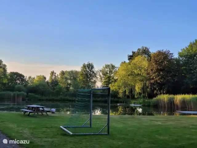 Igloo L'Oasis Verte | Pays-Bas, Brabant-Septentrional, Chaam - bungalow Il y a un magnifique étang de baignade avec une plage, une cabane et une planche de surf.