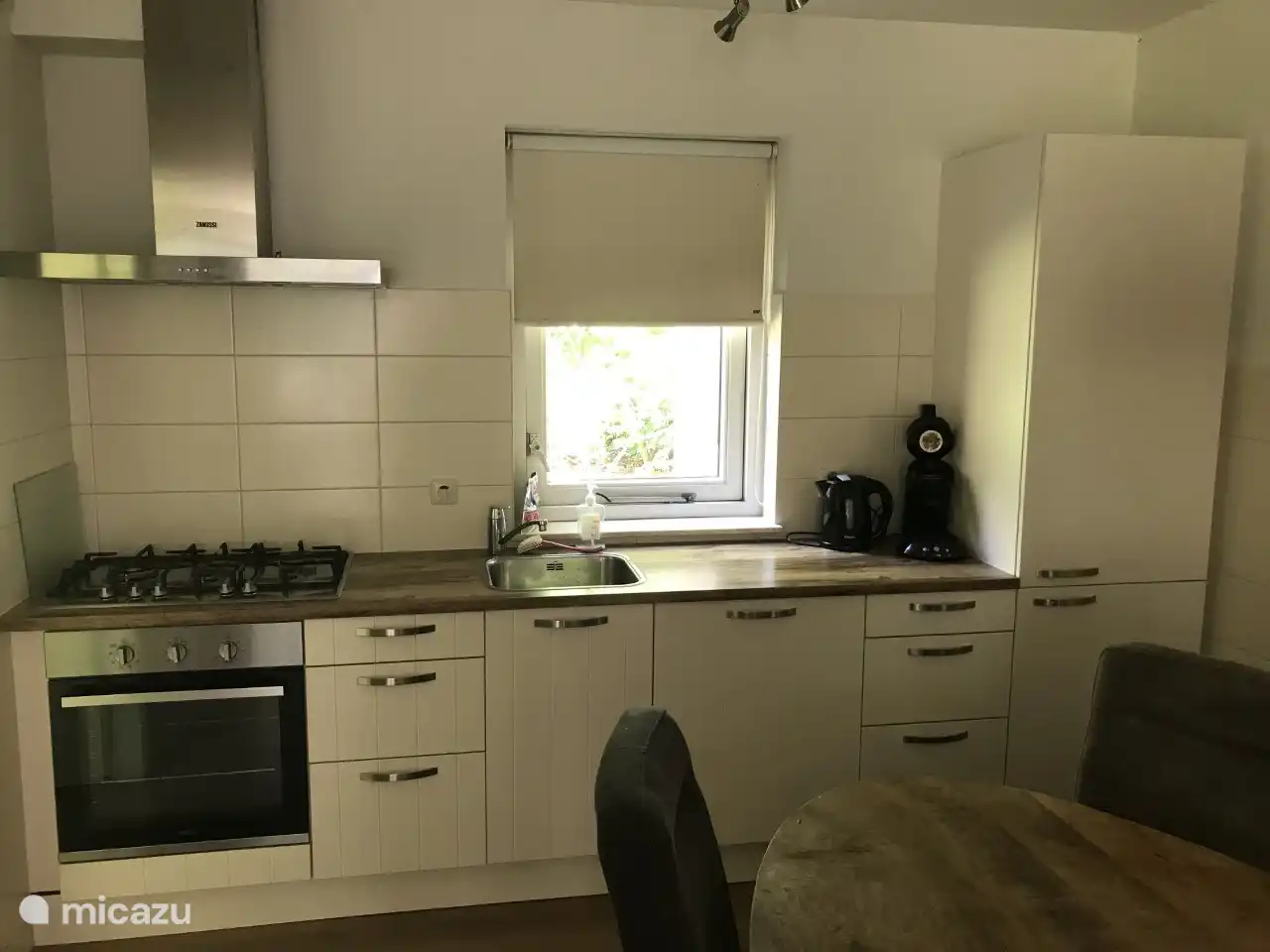 Die Küche mit Gasherd, Backofen, Geschirrspüler und großem Kühlschrank mit Gefrierfach.