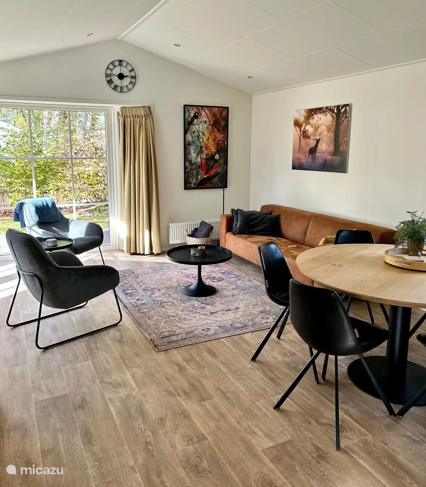 Chalet mit einem geräumigen Wohnzimmer mit Sofa, 2 schönen Relaxsesseln und rundem Esstisch mit 6 Stühlen. Viel Licht durch den Erker mit französischen Türen.

Großer Fernseher mit Schwenkarm vorhanden.