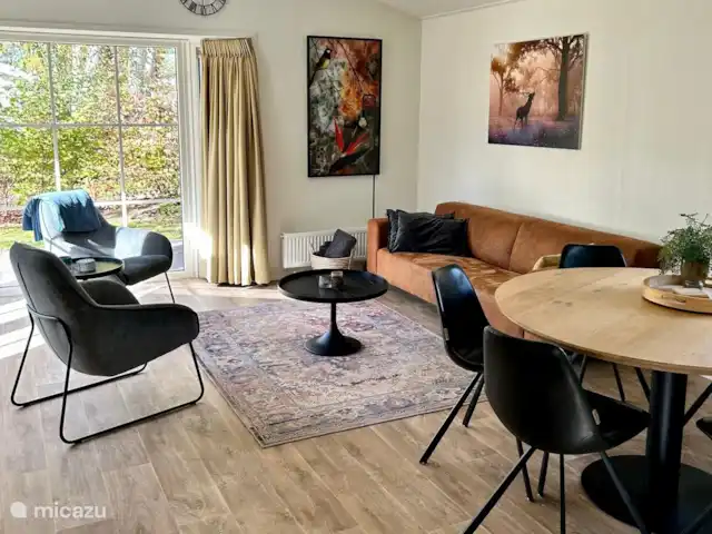 Superhost : Magnifique chalet dans la Veluwe | Pays-Bas, Gueldre, Otterlo - chalet Chalet avec un salon spacieux avec canapé, 2 belles chaises de détente et une table à manger ronde avec 6 chaises. Beaucoup de lumière à travers la baie vitrée avec portes-fenêtres.
Grande télévision avec bras pivotant disponible.