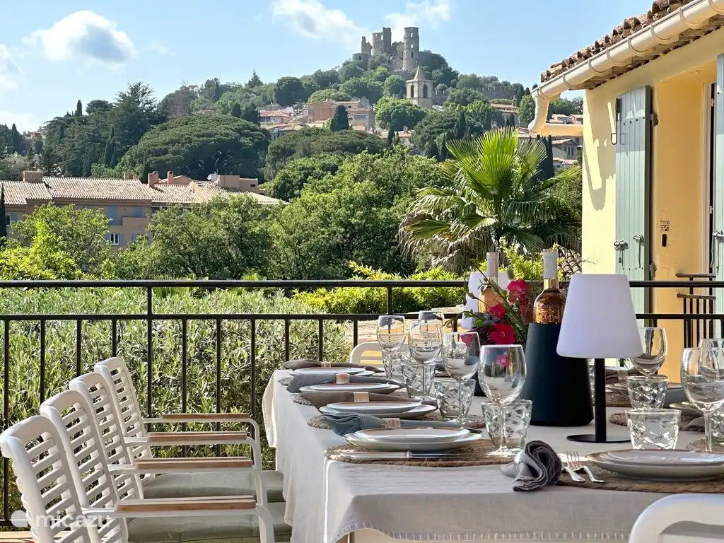 A spacious dining table with a view of the castle of Grimaud