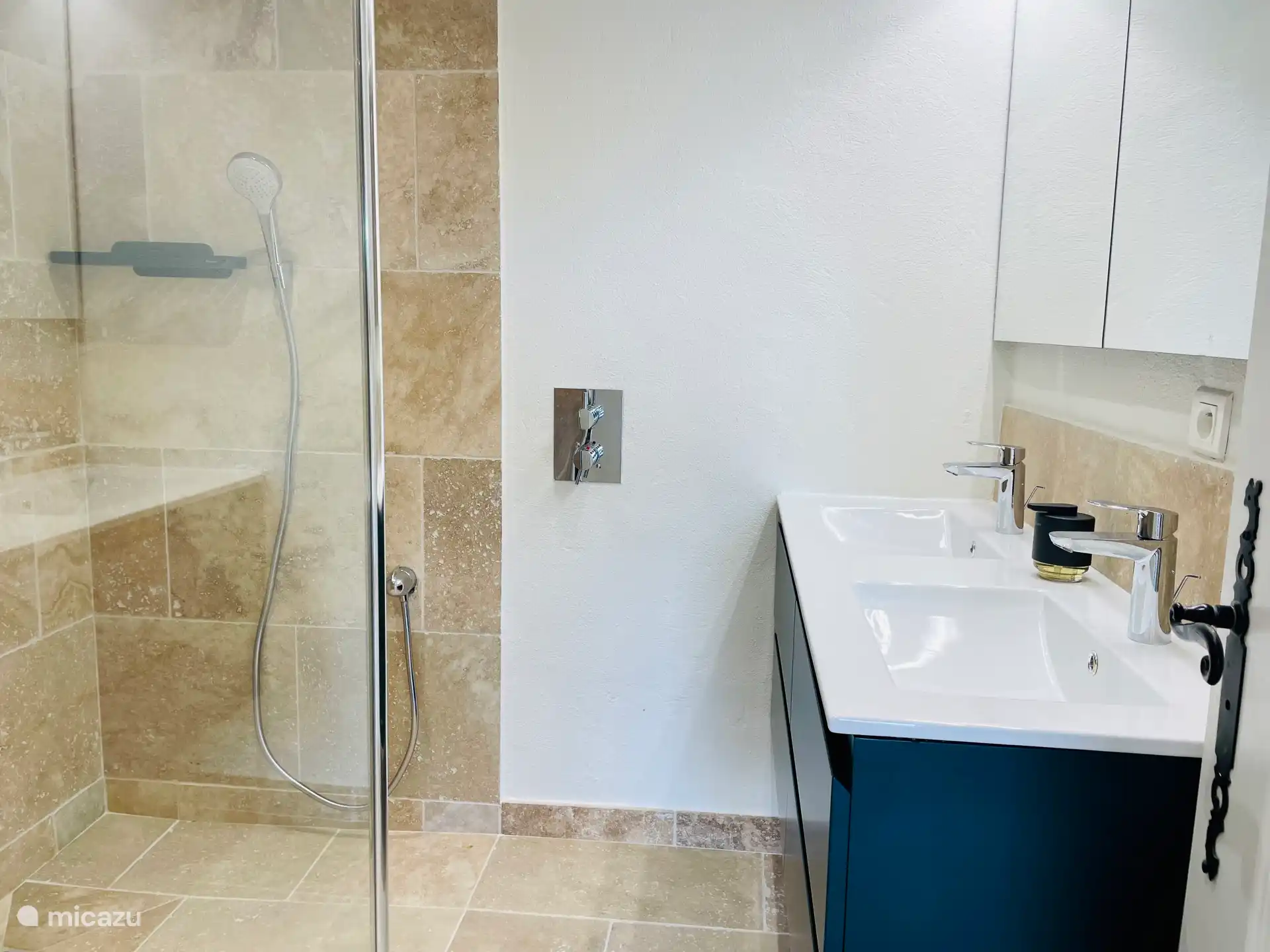 The bathroom of the Pool Apartment with walk-in shower and double sink. Next to it is a separate WC
