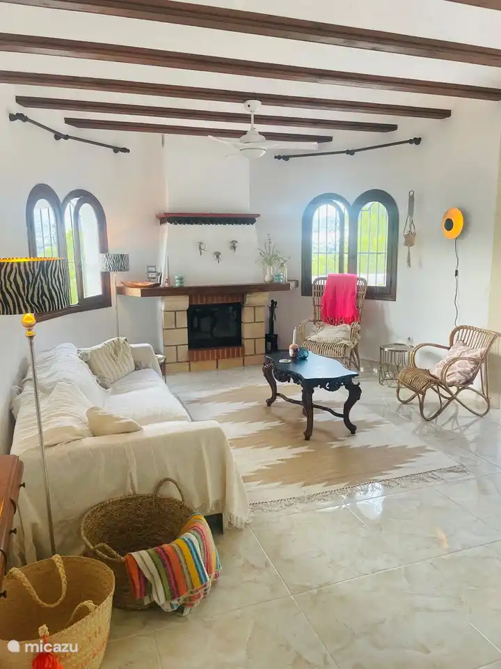 Wohnzimmer im ersten Stock mit Holzofen und Blick auf den Pool und das Tal