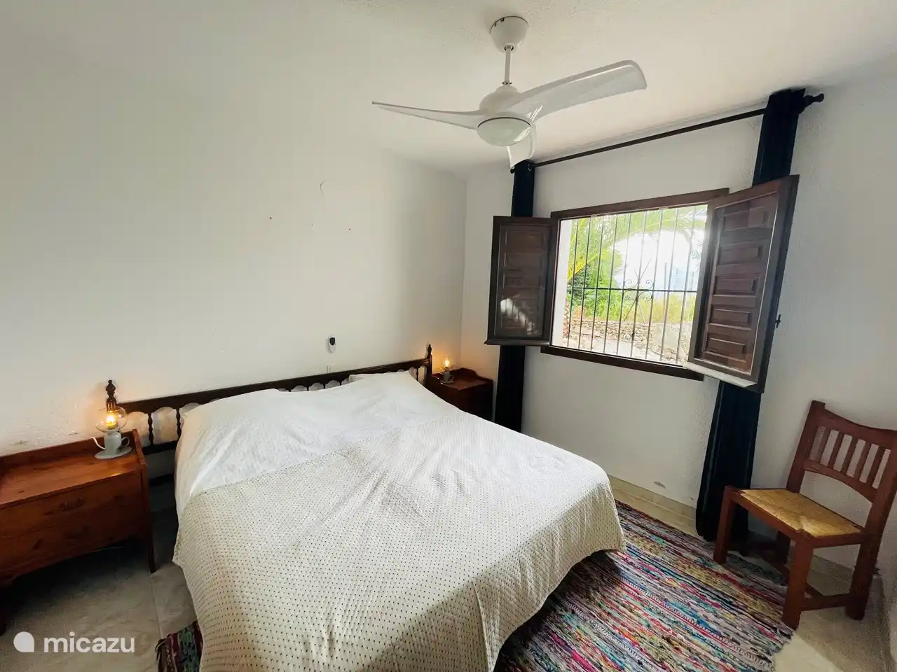 Schlafzimmer 4 im Erdgeschoss mit Fensterläden und Einbauschränken und Ventilator.