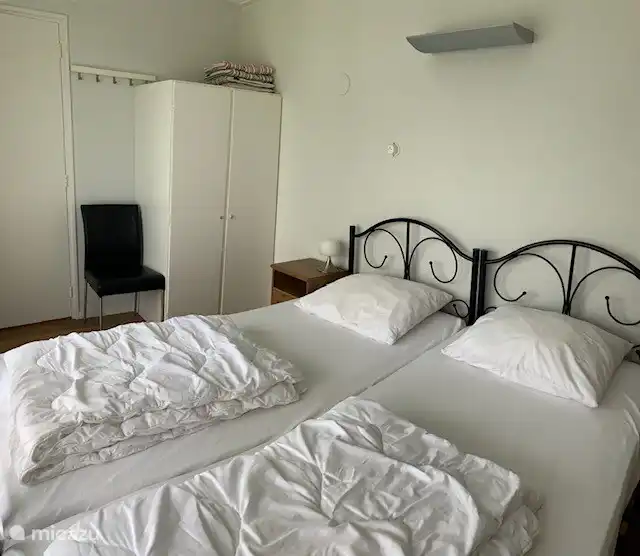 Dormitorio con 2 camas individuales y 2 mesitas de noche con lámparas. Armario separado. Puertas francesas a la terraza y al jardín.