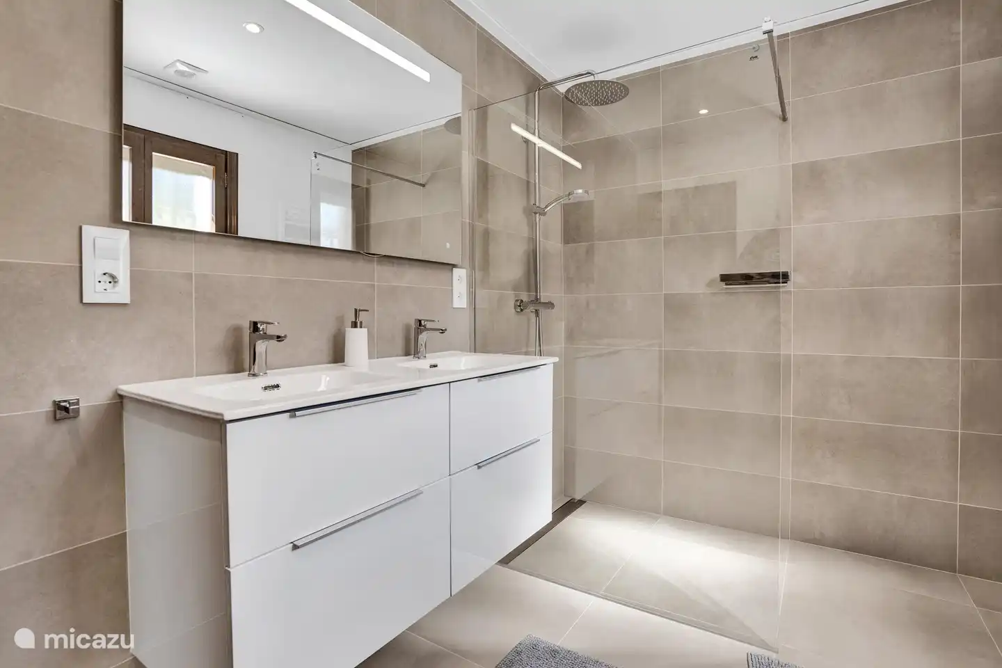 Cette salle de bain dispose d'une double vasque et d'une grande douche à l'italienne.