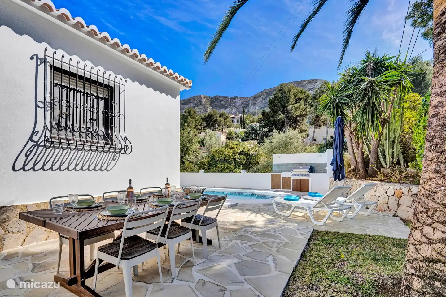 Table de jardin avec 6 places assises à l'arrière de la maison.