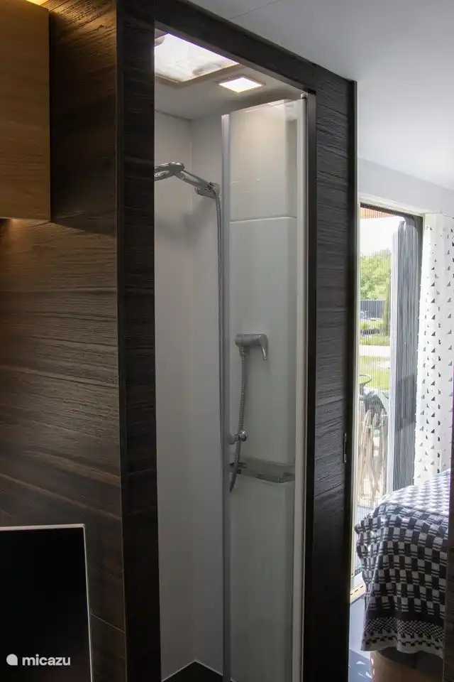 La douche peut devenir une pièce avec la salle de bain grâce à deux portes fermées qui se ferment.