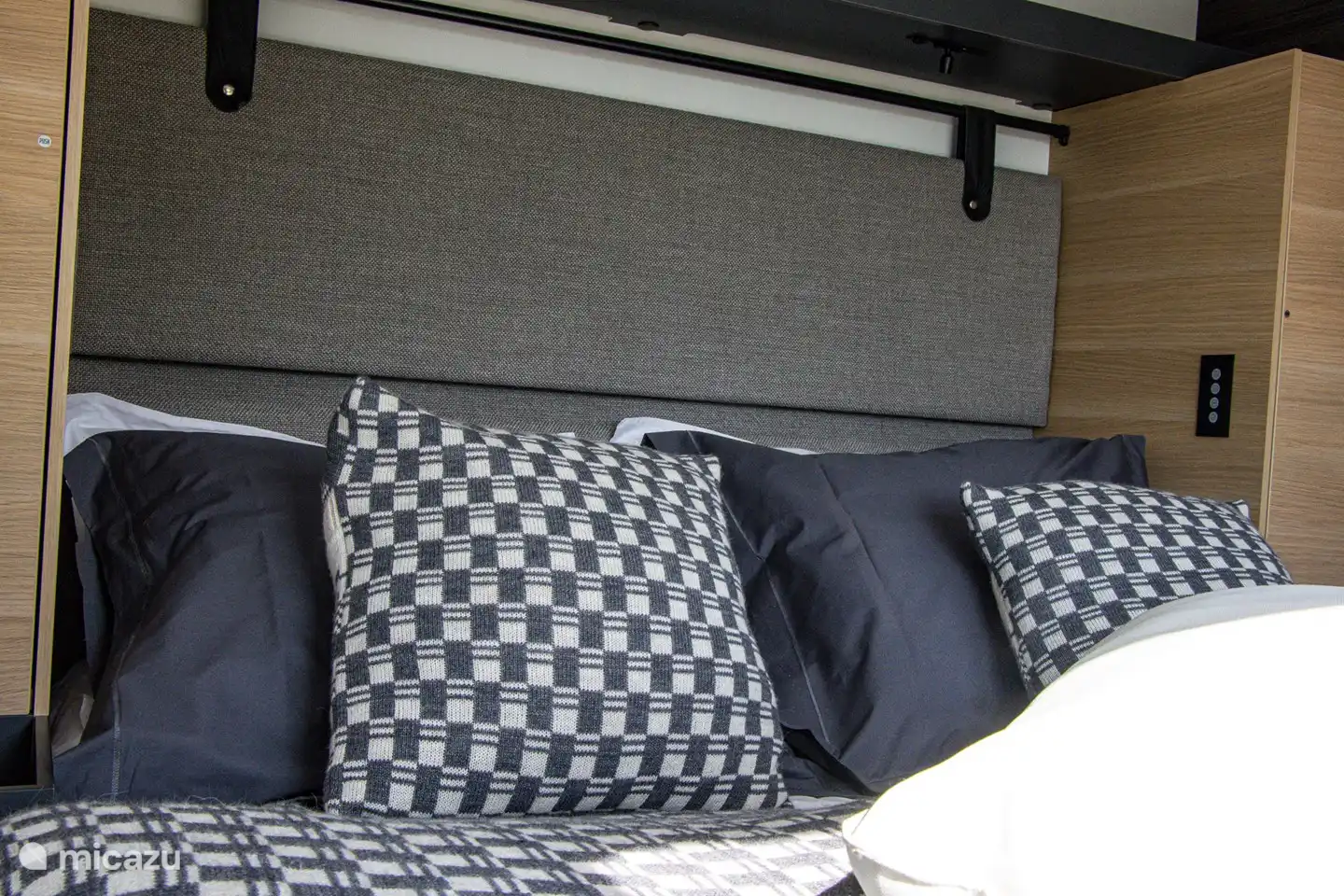 Lit spacieux dans la chambre fixe avec divers placards suspendus / couchés.