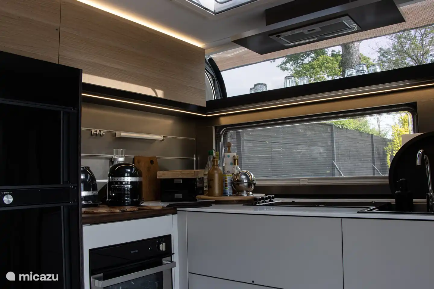 Cuisine avec four, micro-ondes, grand réfrigérateur et congélateur.