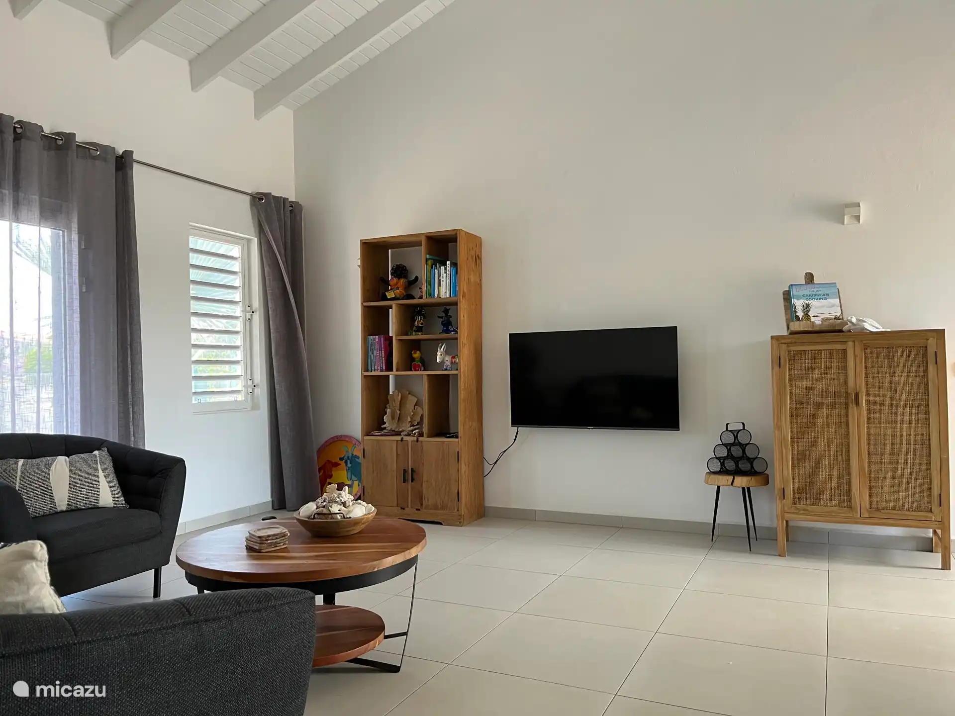 Wohnzimmer mit Smart-TV. Verschiedene Kochbücher der Antillen und Bücher über Curacao sind im Bücherregal vorhanden.