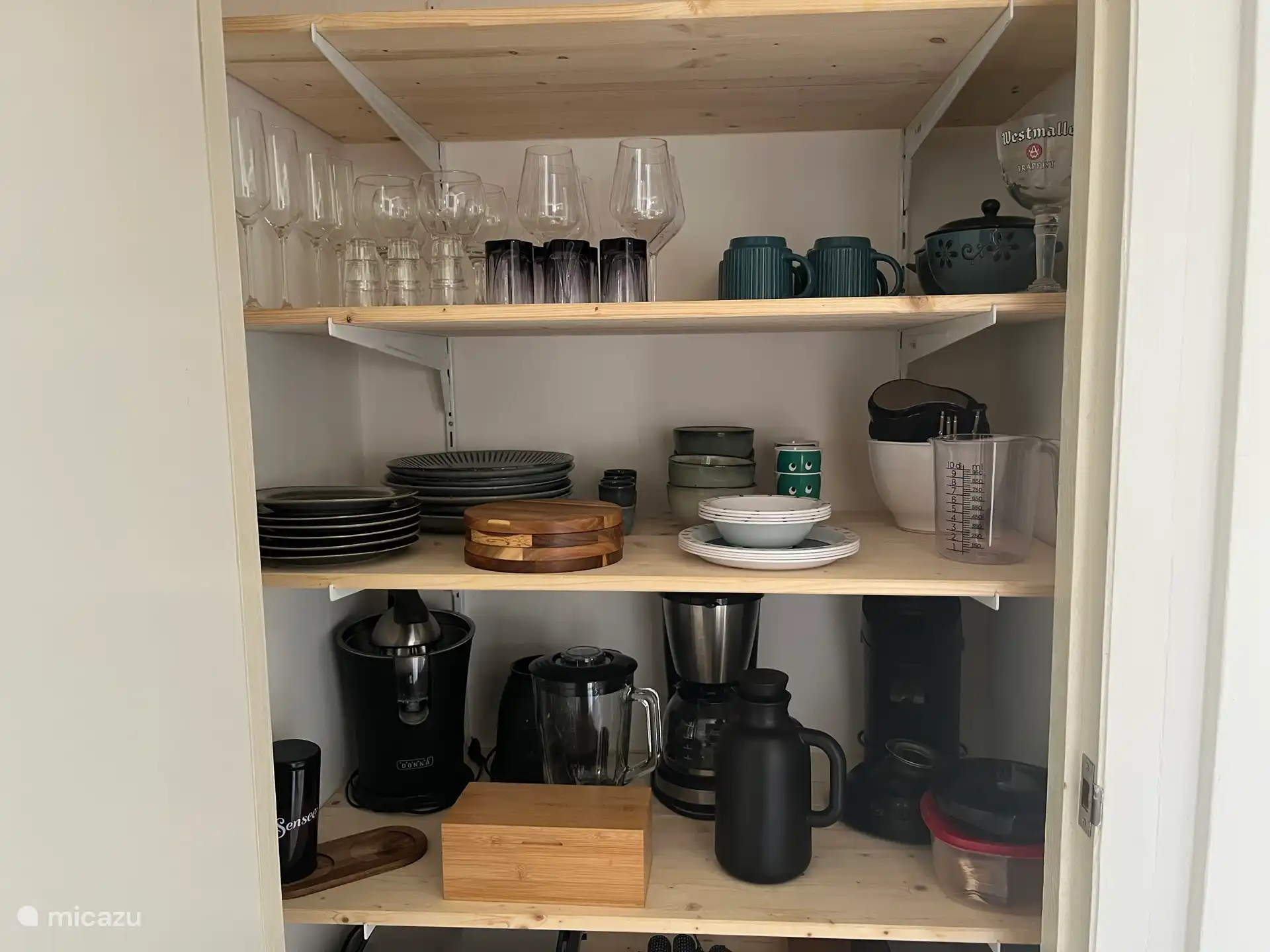 Der Kleiderschrank im Wohnzimmer ist mit verschiedenen Küchenutensilien ausgestattet.