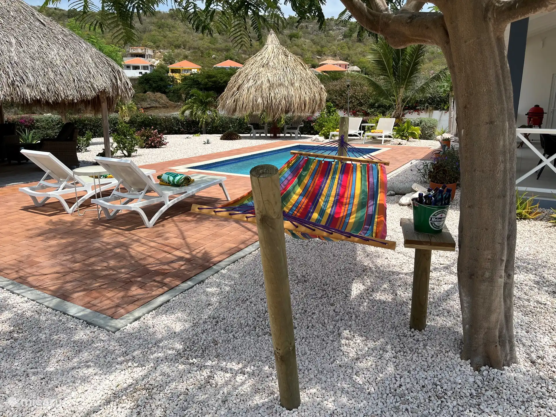 Pooldeck mit Sonnenliegen und Hängematte