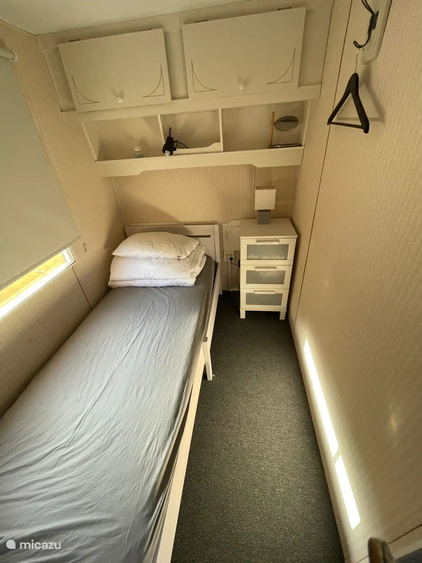 Chambre 2. Voici un lit 1 personne avec une couette 1 personne. Il y a une commode et des armoires supérieures. Portemanteau. 