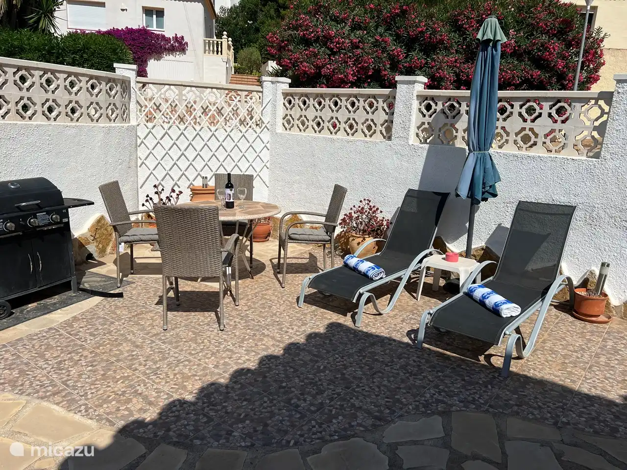 Komplett eingezäunte Terrasse mit Gasgrill, Esstisch und zwei Sonnenliegen
