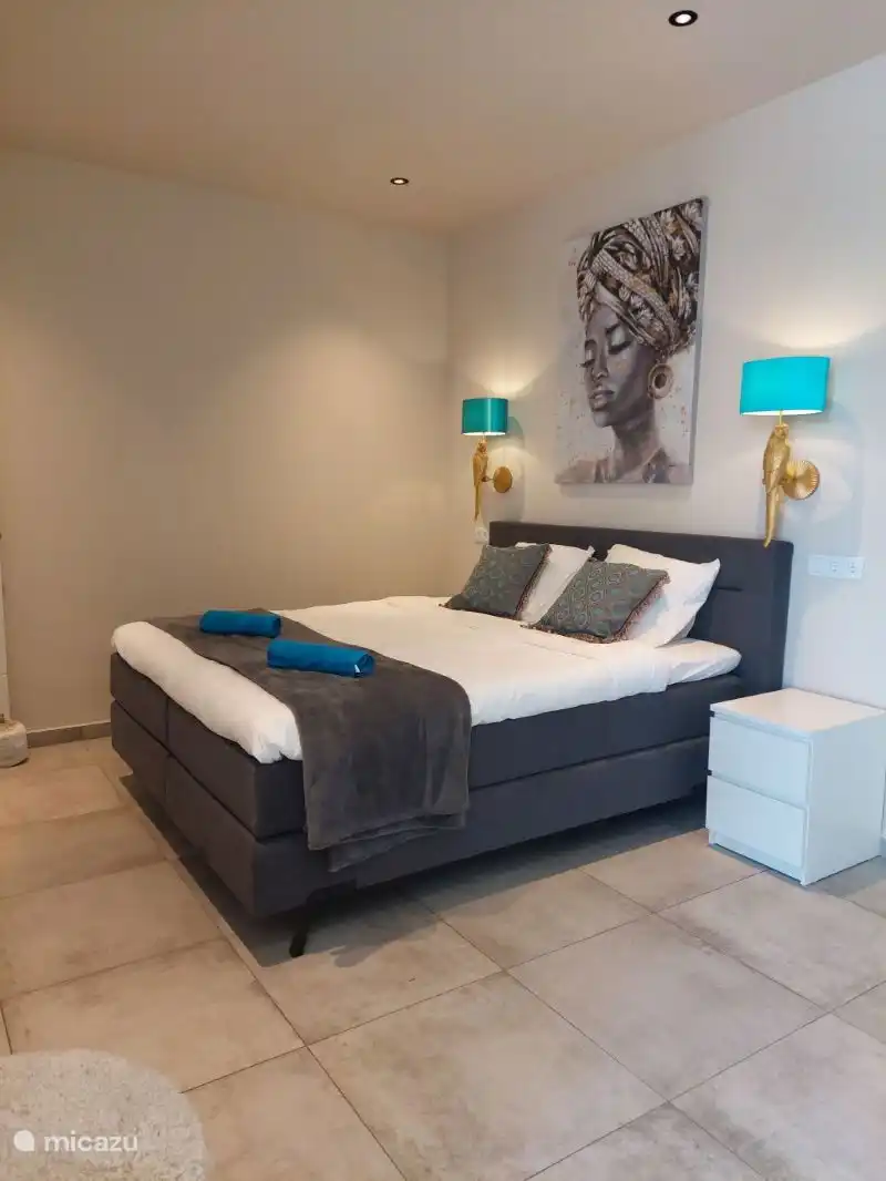 La première chambre avec un lit king size et une salle de bain attenante