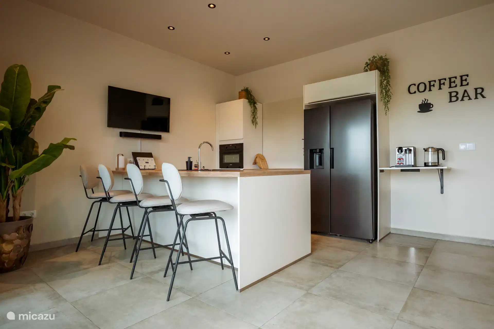 La cocina moderna y totalmente equipada con nevera americana