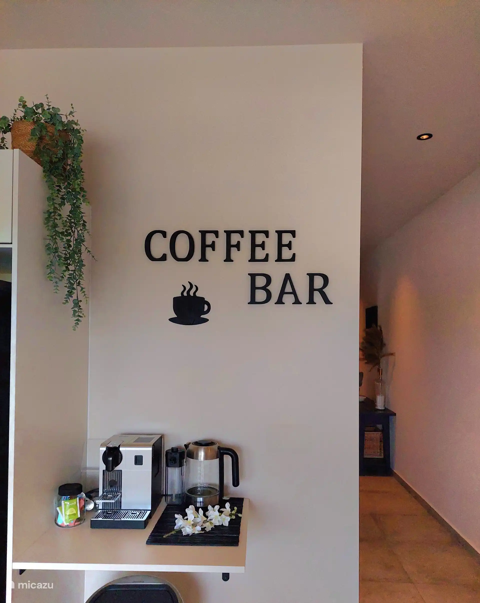 Un « bar à café » avec une machine à café Nespresso et une bouilloire.
