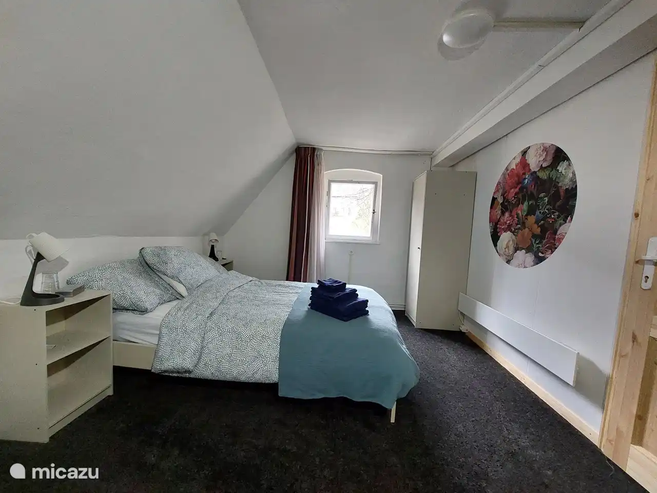 The bedroom has a double bed, 2 bedside tables with bedside lamps and an alarm clock, a chest of drawers and a hanging / laying wardrobe.