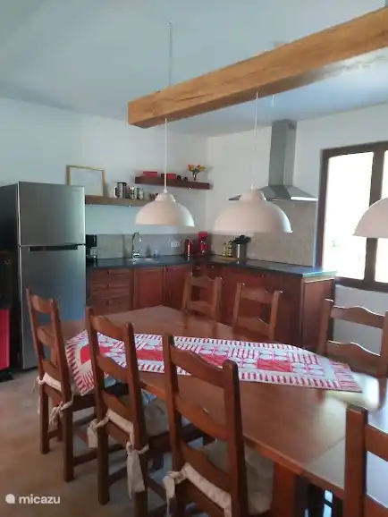 Cocina abierta con horno pequeño, microondas, nevera con congelador.