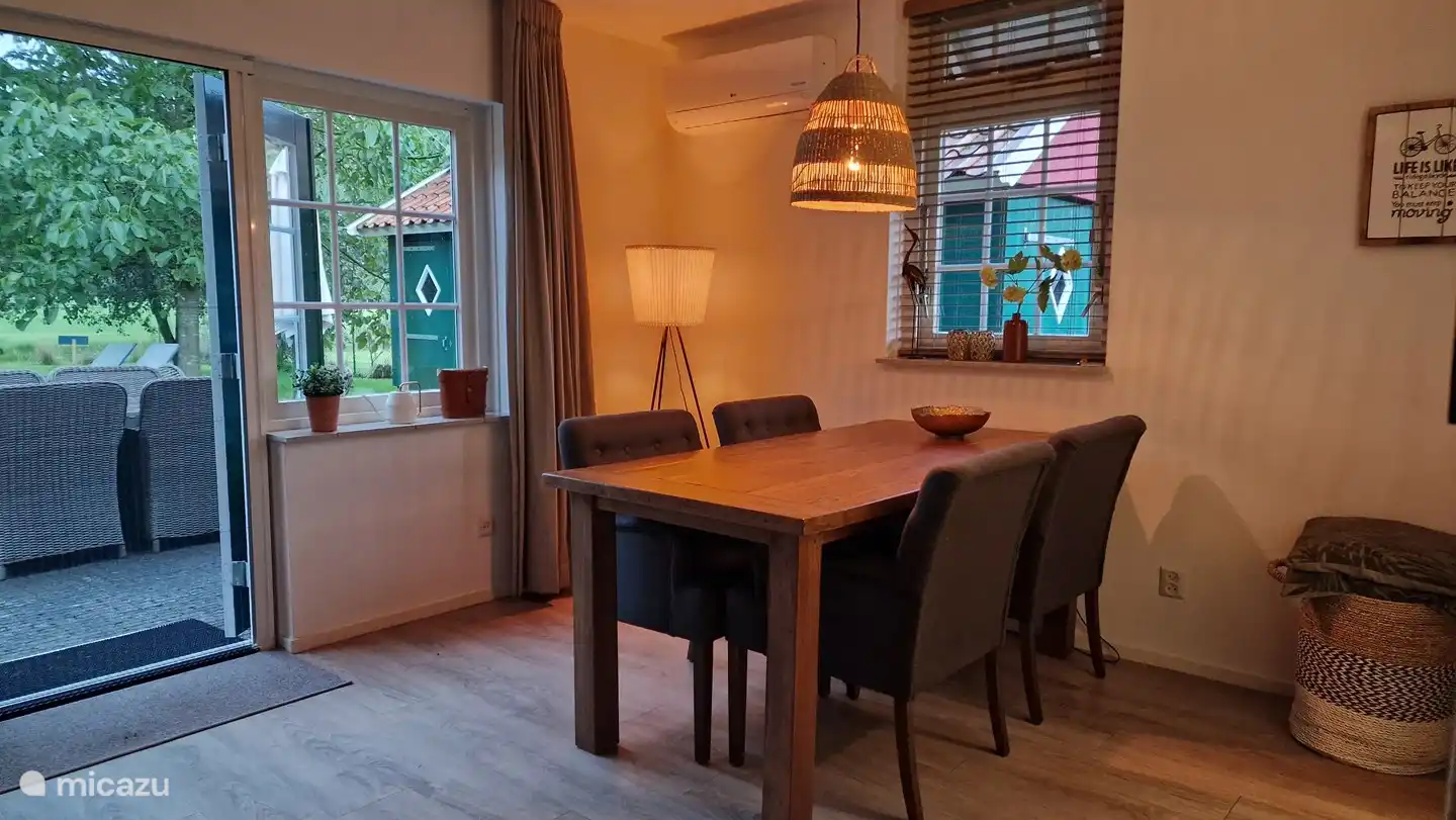 Essbereich mit vier Stühlen. Es werden lose Stühle für mehr Personen hinzugefügt.