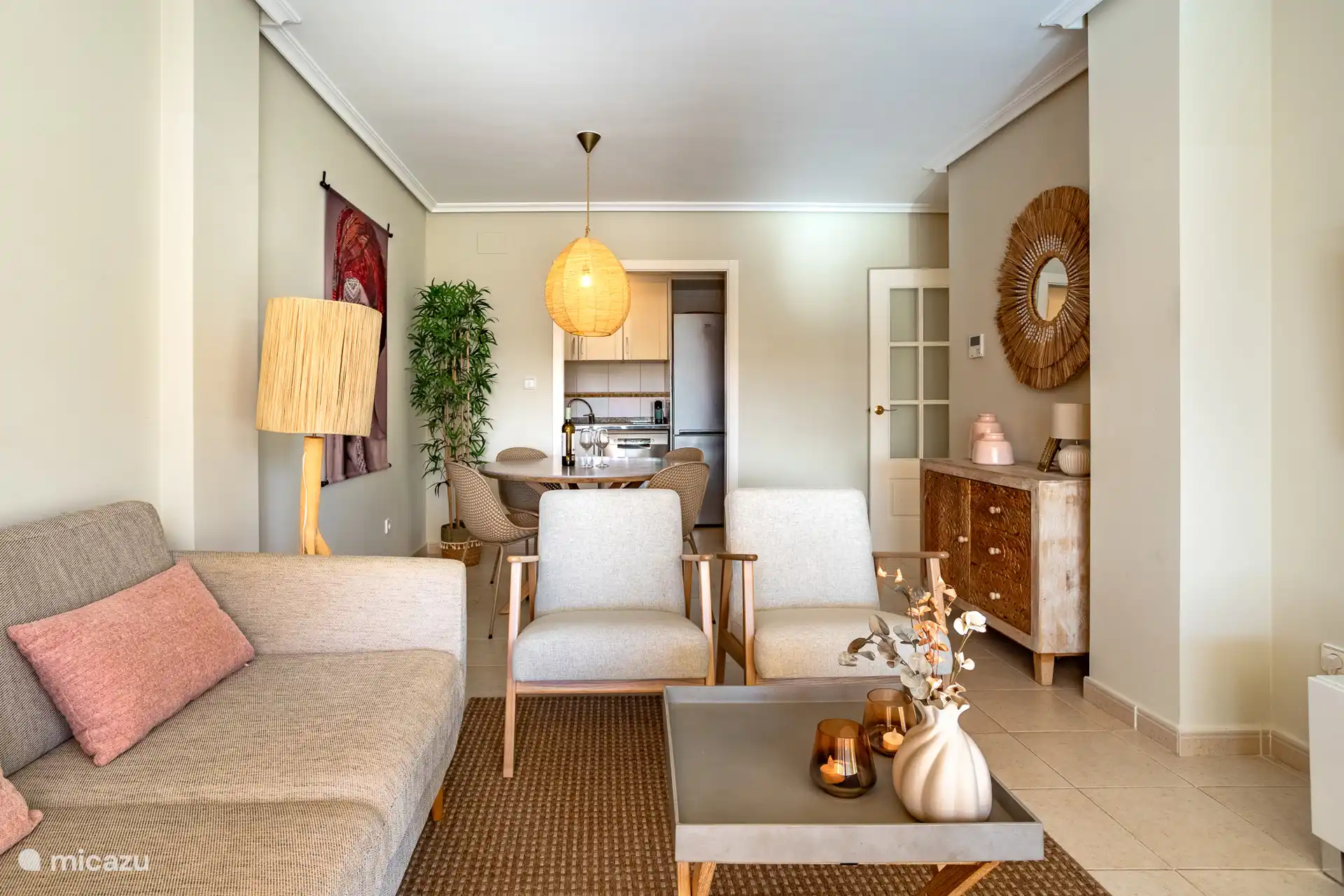 Woonkamer voorzien van tweezitsbank, twee stoelen en 4-persoons eettafel.