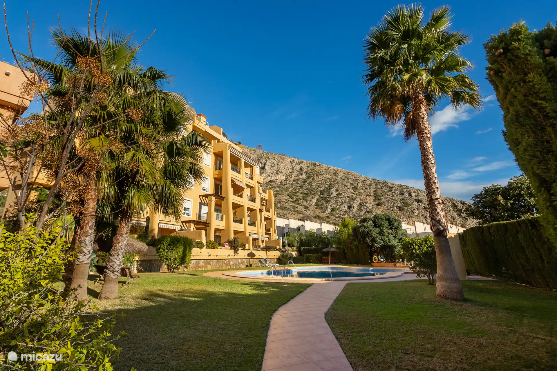 Dit is het eerste zwembad. Hier kun je een ligbedje pakken. Er zijn parasols, er is een douche en een toillet.