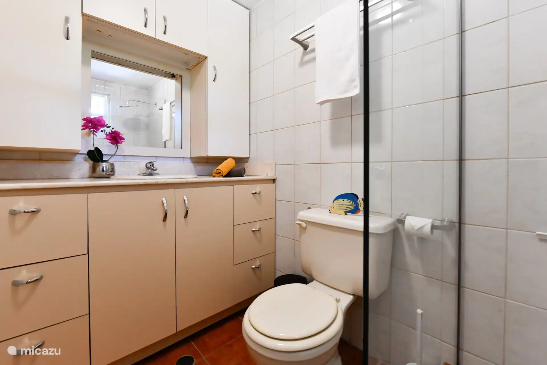 Angrenzend an das Hauptschlafzimmer befindet sich ein Badezimmer. Dieses Badezimmer ist komplett mit Dusche, großem Waschbecken mit viel Stauraum und WC ausgestattet
