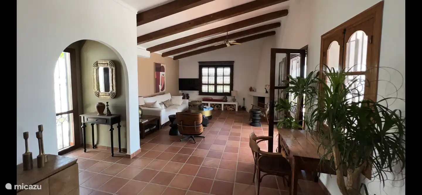 Das Wohnzimmer mit offener Küche ist sehr geräumig. Die Terrassentüren führen direkt auf die Terrasse mit Garten und Pool auf der gleichen Ebene.