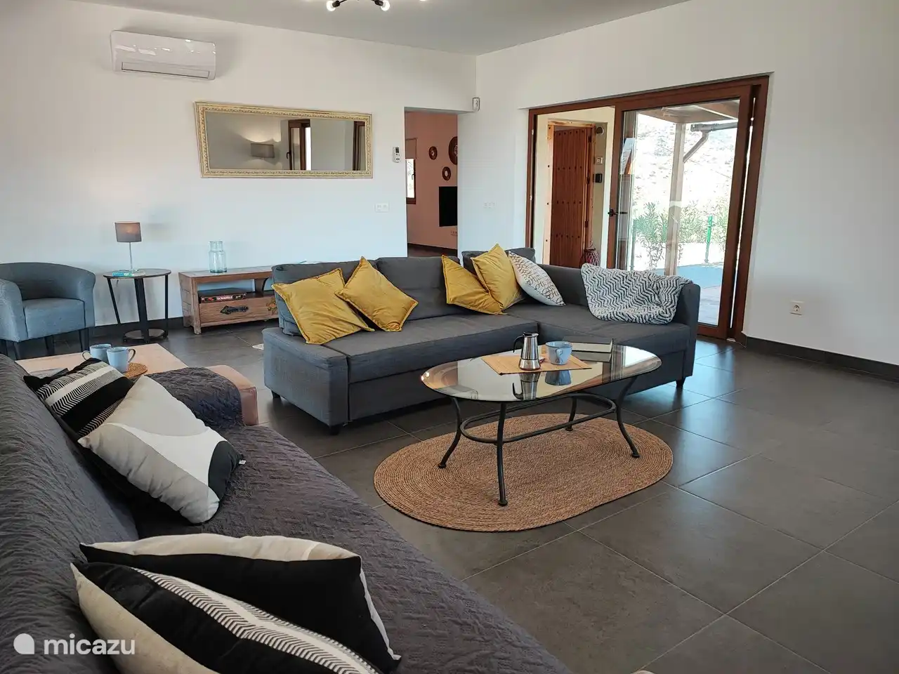 Salon avec portes patio donnant sur les terrasses et la piscine.