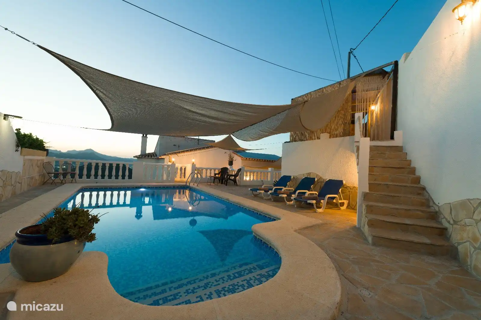 Die Terrasse verfügt über viel stimmungsvolle Beleuchtung, Zugang zum Whirlpool und Blick auf die Berge.