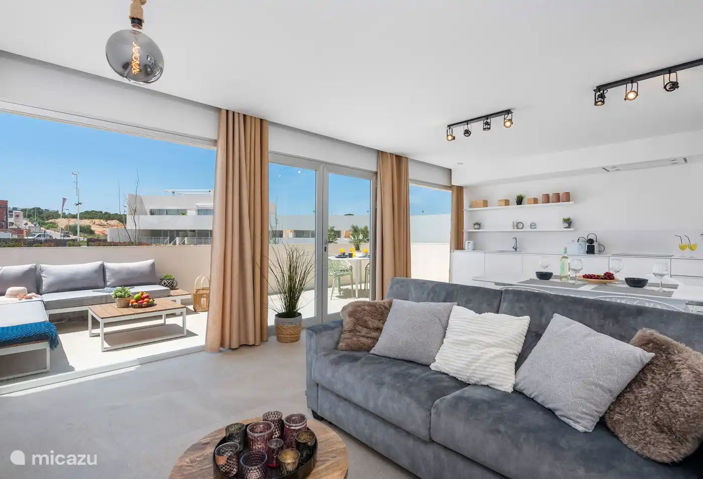 sala de estar con sofá cama y vista a la cocina y terraza