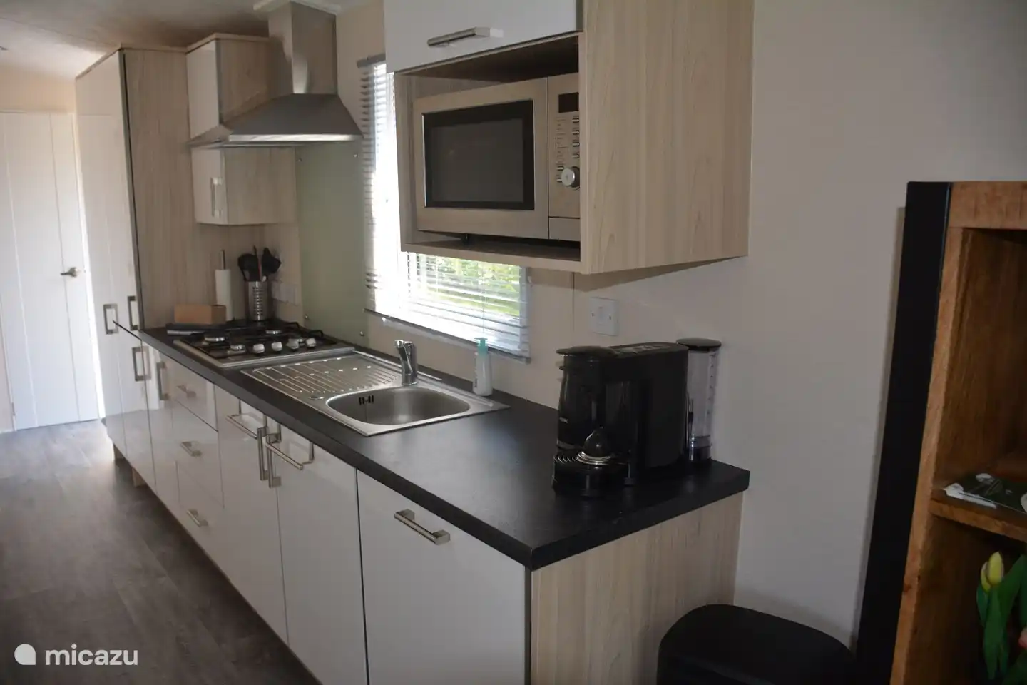 De keuken is compleet uitgerust met o.a. een koel/vriescombi, een vaatwasser, combi magnetron, 4 pits gasfornuis, koffiezetapparaat en waterkoker. 