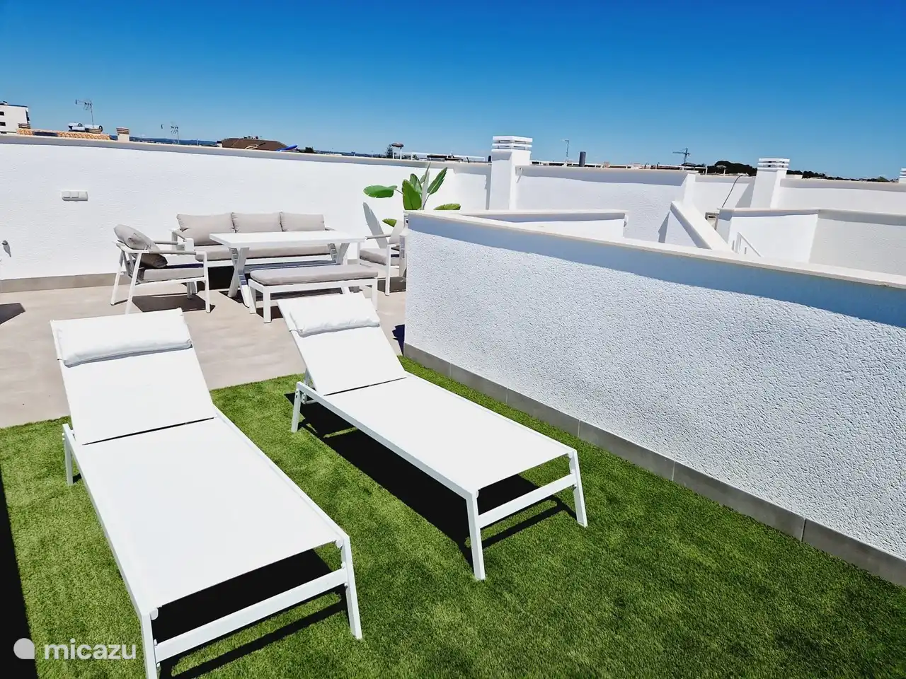 Solarium - Dachterrasse mit einem geräumigen Lounge-Set und 2 Sonnenliegen.