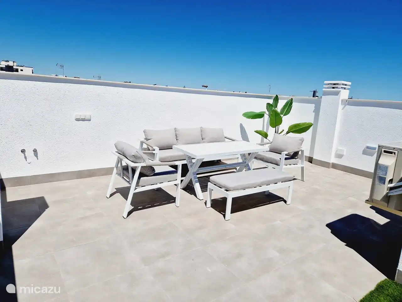 Solarium - Dachterrasse mit einem geräumigen Lounge-Set und 2 Sonnenliegen.
