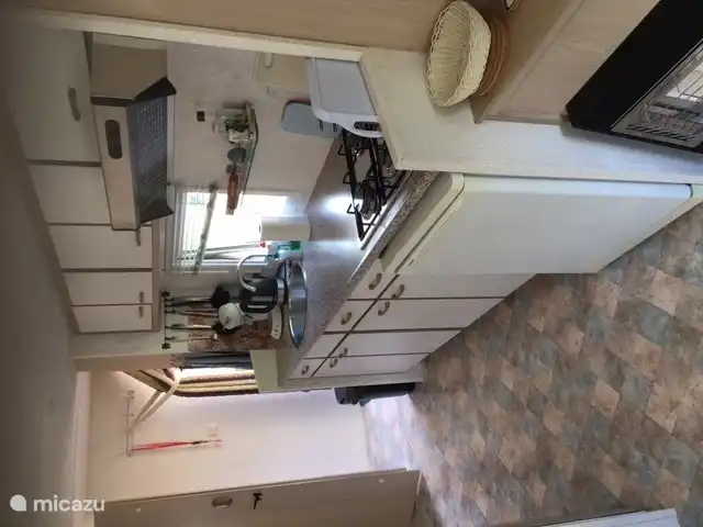 Cocina con cocina a gas de 4 fuegos y campana extractora con frigorífico con congelador debajo. Cafetera Senseo y tetera. Armarios con cristalería, cubertería y vajilla y todo tipo de sartenes.